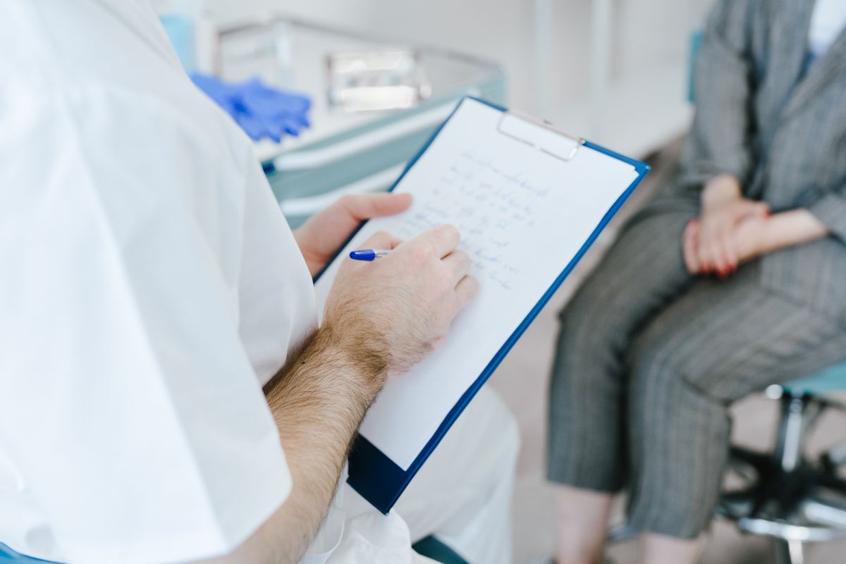 Doctor reviewing rhinoplasty consultation notes with a patient